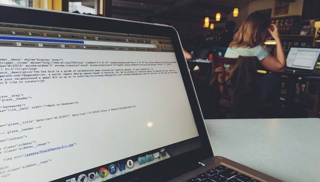 An illustration showing a laptop with various coding symbols and languages on the screen, surrounded by icons representing online learning platforms like Codecademy, Coursera, edX, Khan Academy, and FreeCodeCamp. The background features a digital world map, symbolizing global accessibility to free coding education.